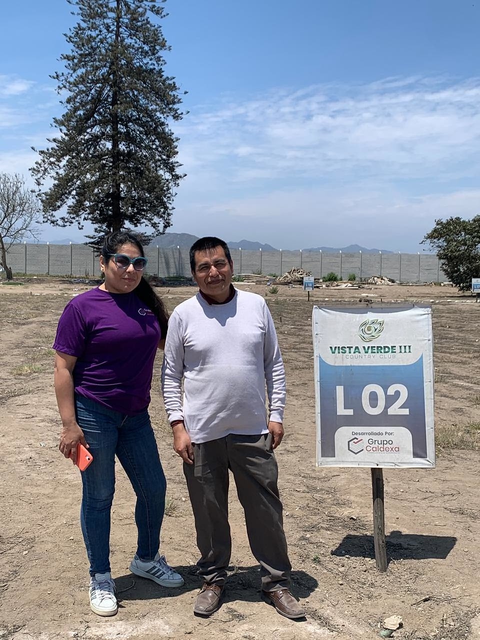 Margarita con un cliente junto al cartel del lote L02 de Vista Verde III, hoy agotado