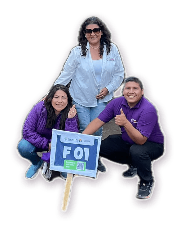 Clientes de Margarita junto al cartel de su lote F-01, entre mandarinos en Huaral